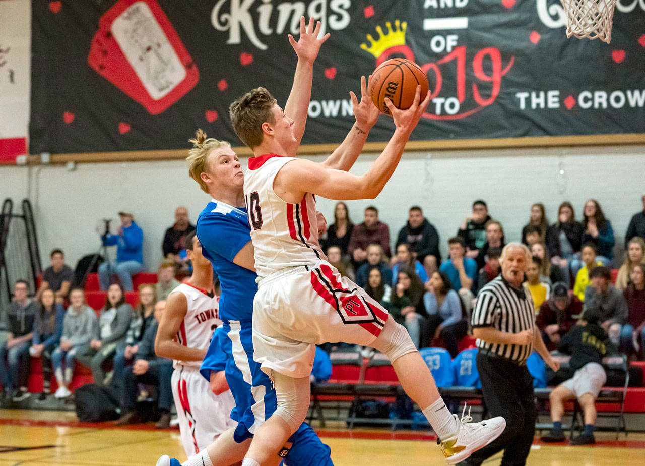 Steve Mullensky/for Peninsula Daily News Port Townsends Cole Crawford jumps past Chimacums Cody Clark and goes up for a layup during a game in Port Townsend on Friday night.