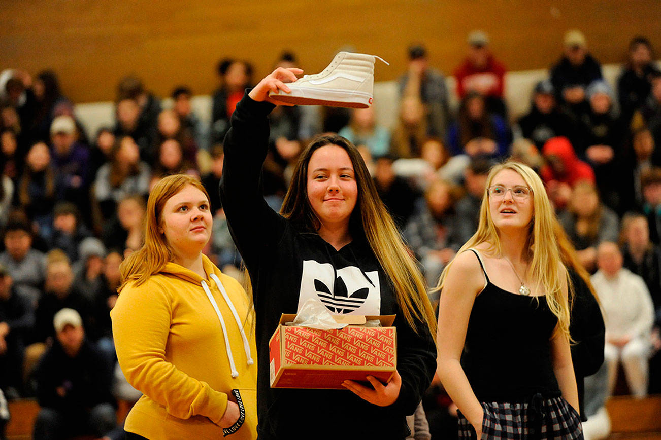Samantha White shows her new kicks she received from one of Sonja Miller’s classes as a gift to the crowd during the Winter Wishes assembly. White said the shoes were “fresh.” (Matthew Nash /Olympic Peninsula News Group)