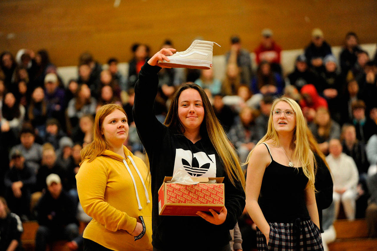 Samantha White shows her new kicks she received from one of Sonja Miller’s classes as a gift to the crowd during the Winter Wishes assembly. White said the shoes were “fresh.” (Matthew Nash /Olympic Peninsula News Group)