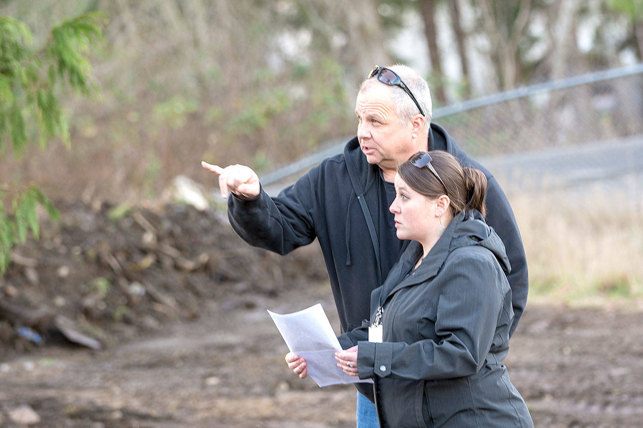Clallam County Code Enforcement Officer Rich Meyer and program administrator Lindsey Aspelund look over the recently cleaned property at 2337 E. Pioneer Road on Monday. (Jesse Major/Peninsula Daily News)