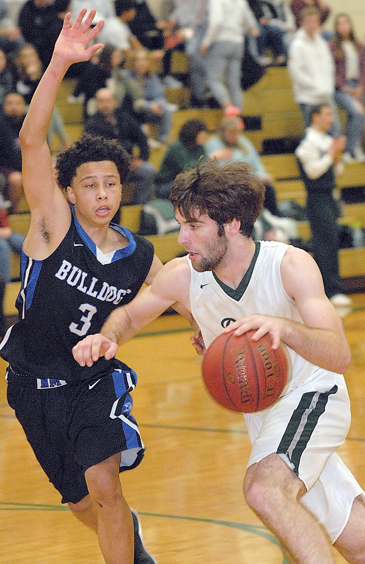 Port Angeles’ Garrett Edwards, right, drives to the lane past the defense of North Mason’s Joe Crosswhite on Friday night at Port Angeles High School. (Keith Thorpe/Peninsula Daily News)