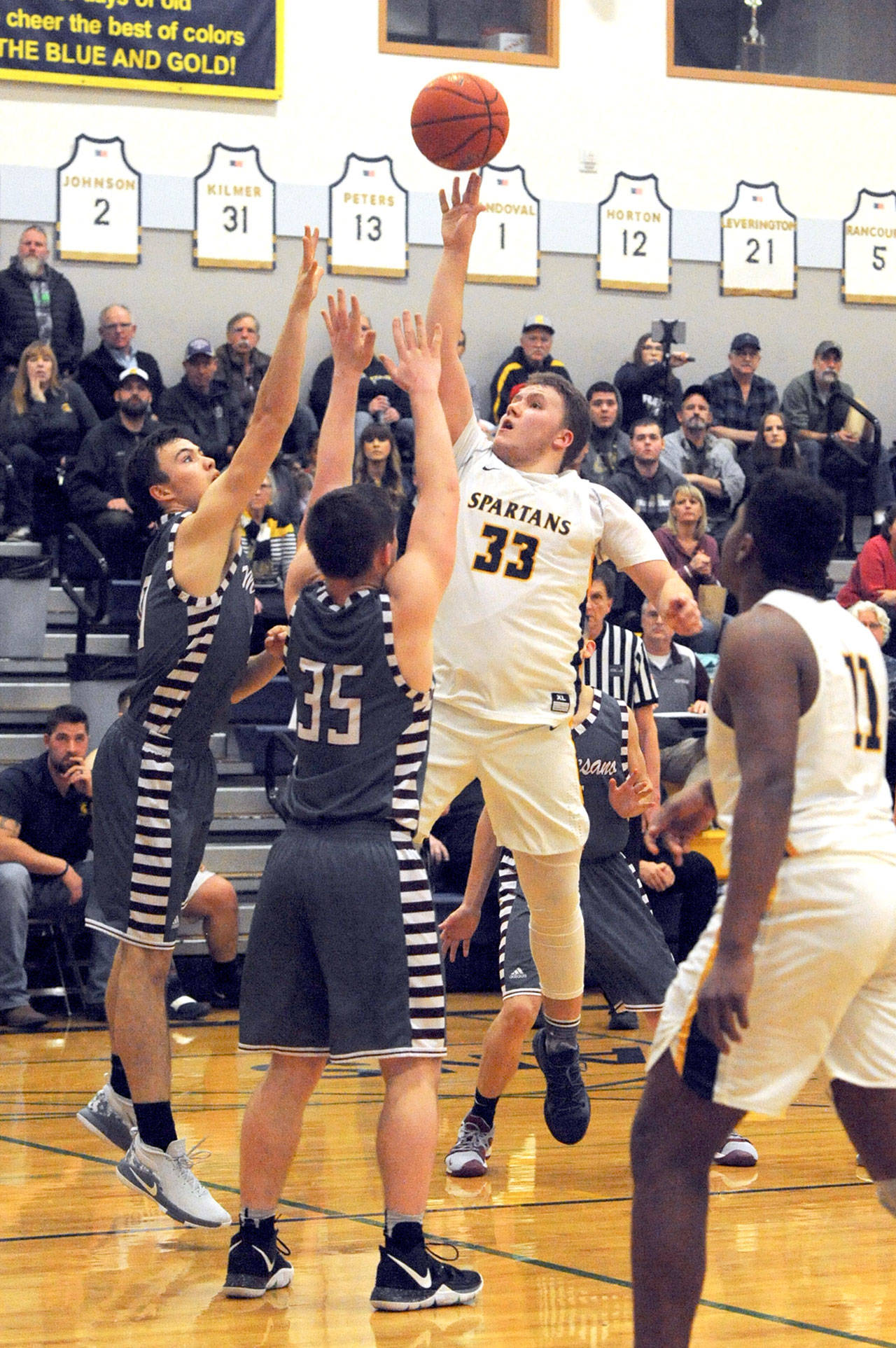 Lonnie Archibald/for Peninsula Daily News Forks’ Cort Prose (33) puts up a shot over Montesano defenders Trace Ridgway (left) and Shaydon Farmer during the Spartans’ 67-63 loss to the Bulldogs.