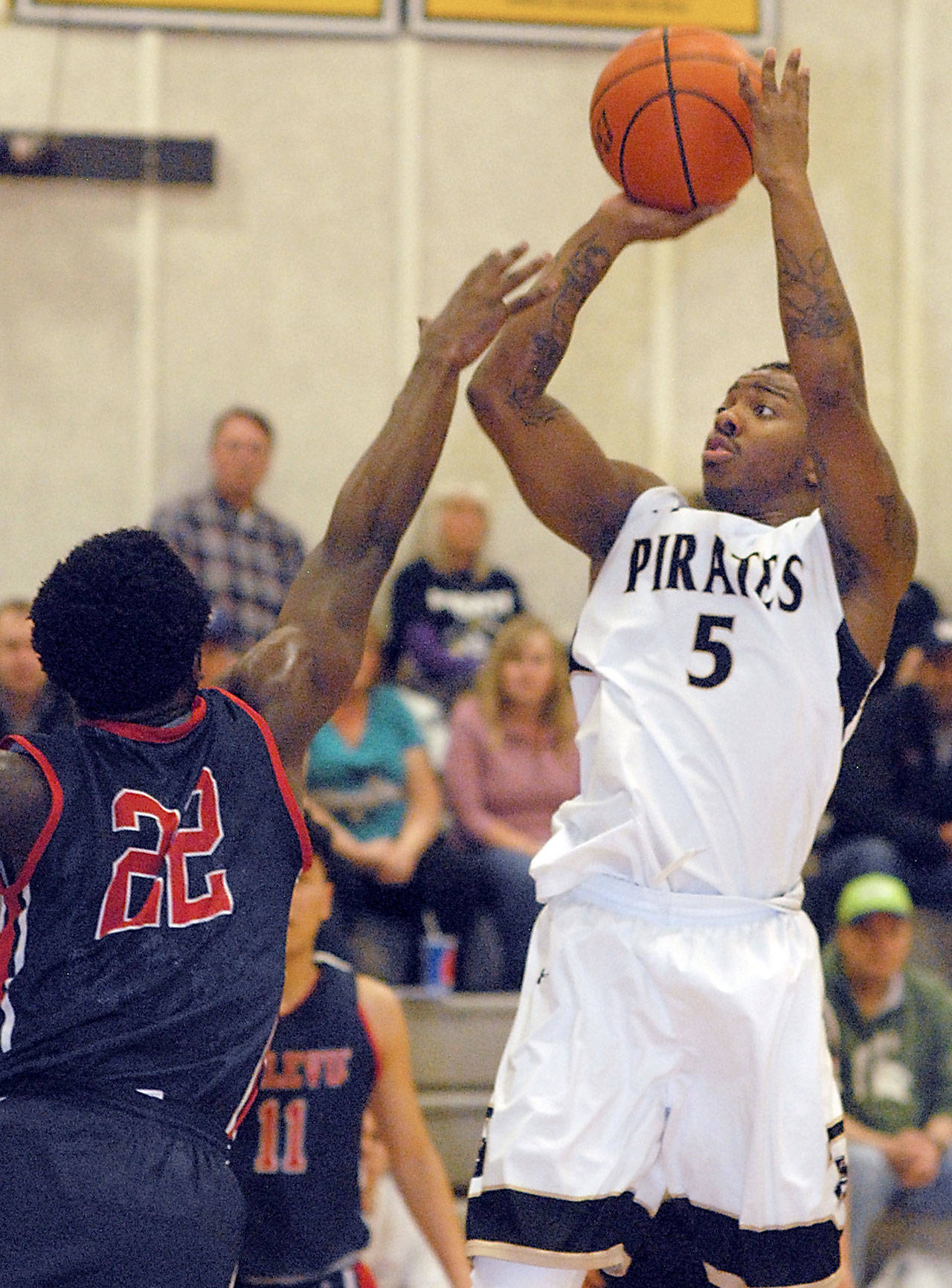 Keith Thorpe/Peninsula Daily News Peninsula’s Nyair Cleveland, right, take aim at the hoop as Bellevue’s Malik Sanchez defends on Wednesday evening on the Pirates’ home court in Port Angeles.