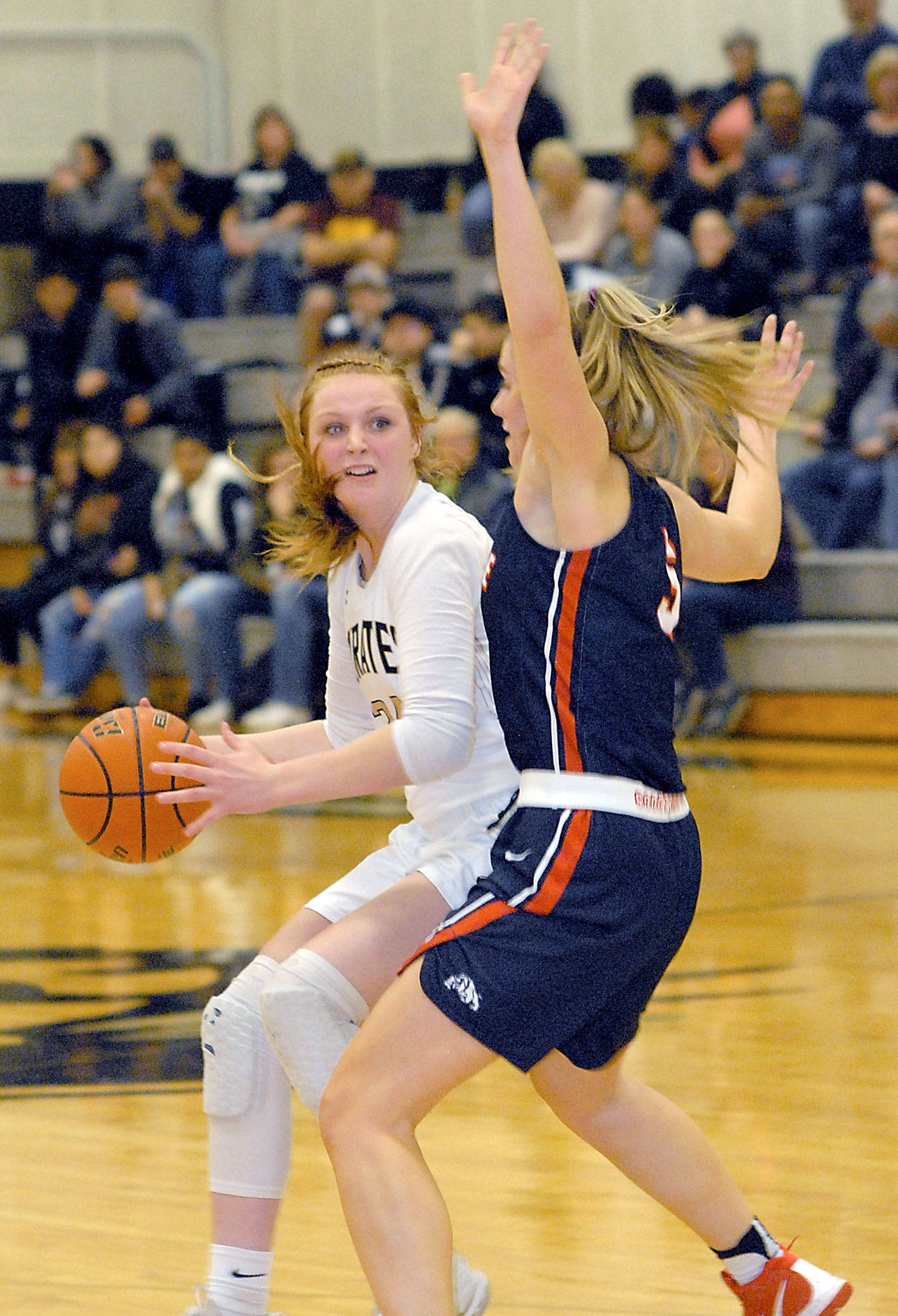 Keith Thorpe/Peninsula Daily News Peninsula’s Kameron Bowen, left, looks around the defense of Bellevue’s Natalie Amos in the third quarter on Wednesday night in Port Angeles.