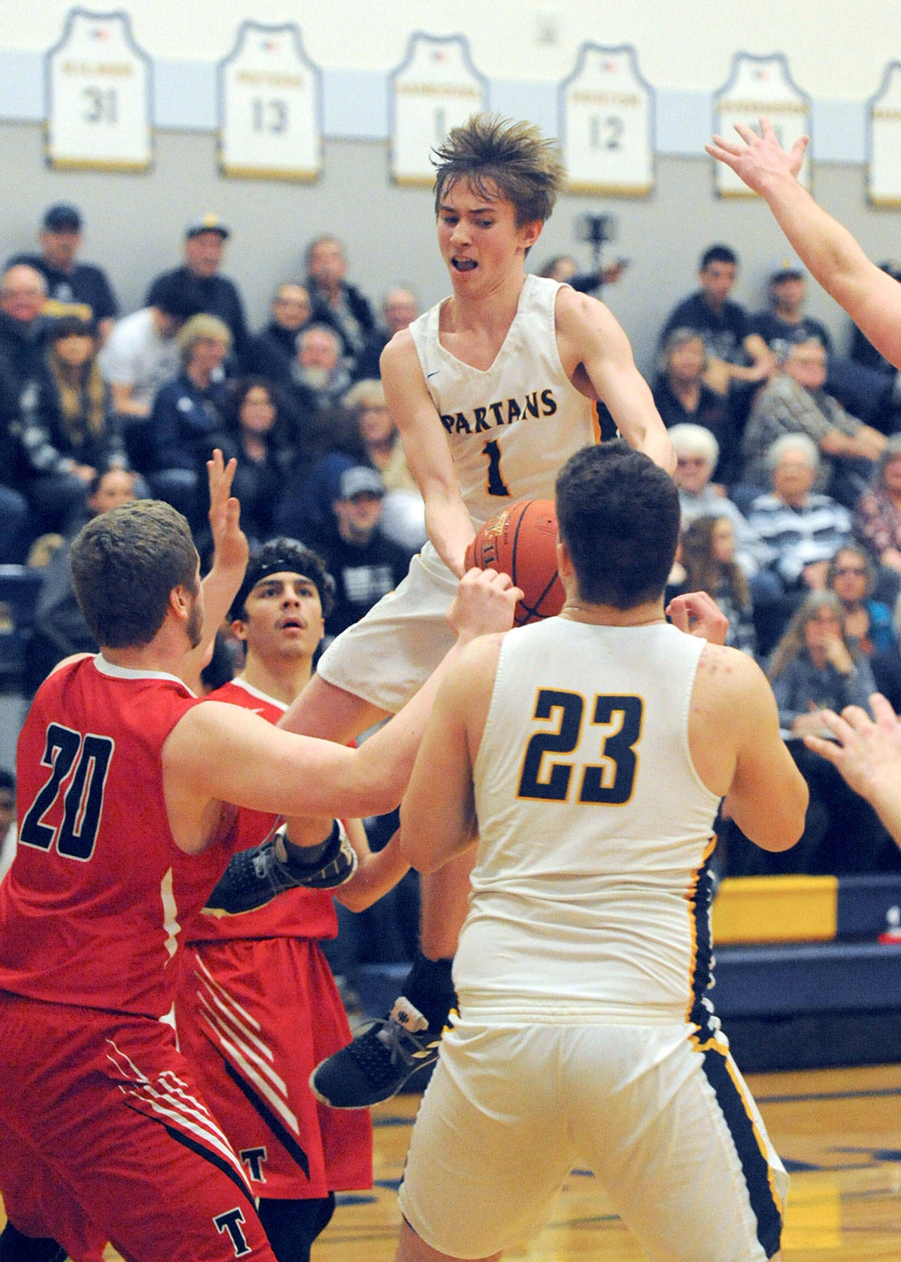 Spartan Seth Johnson (1) drives the lane against Tenino’s Alex Bratton (20) and Frisco Villa Friday night in Forks where the Spartans defeated Tenino to remain tied with Montesano for first place in the Evergreen 1A league. Looking on is Forks’ Braton Armas. Forks 69 Tenino 53. Lonnie.