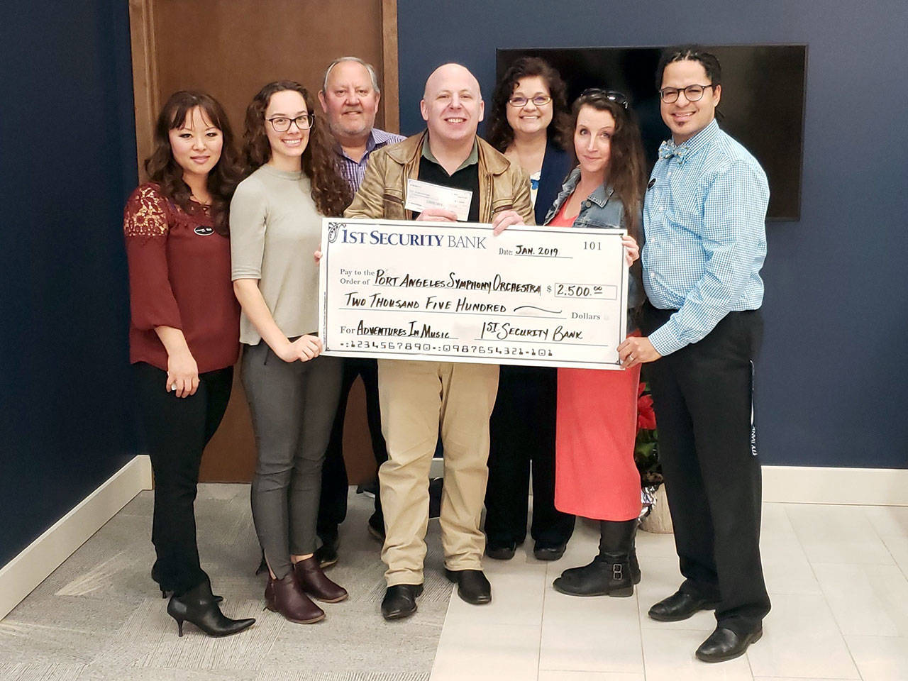 A $2,500 donation is presented to the Port Angeles Symphony’s Adventures in Music program at 1st Security Bank in Port Angeles. From left are bank staffers Rui Starrett, Danielle Lorentzen and Jeff Allen, Port Angeles Symphony conductor Jonathan Pasternack, Elisa Simonsen, symphony board member Lisa Harvey-Boyd and bank officer/symphony violist Tyrone Beatty.