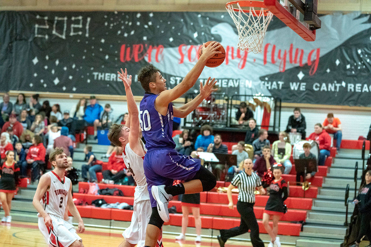 Sequim’s Hayden Eaton goes up for a pair of points despite the defense of Port Townsend’s Nico Winegar during the Wolves’ win over the Redhawks on Tuesday. Steve Mullensky/for Peninsula Daily News