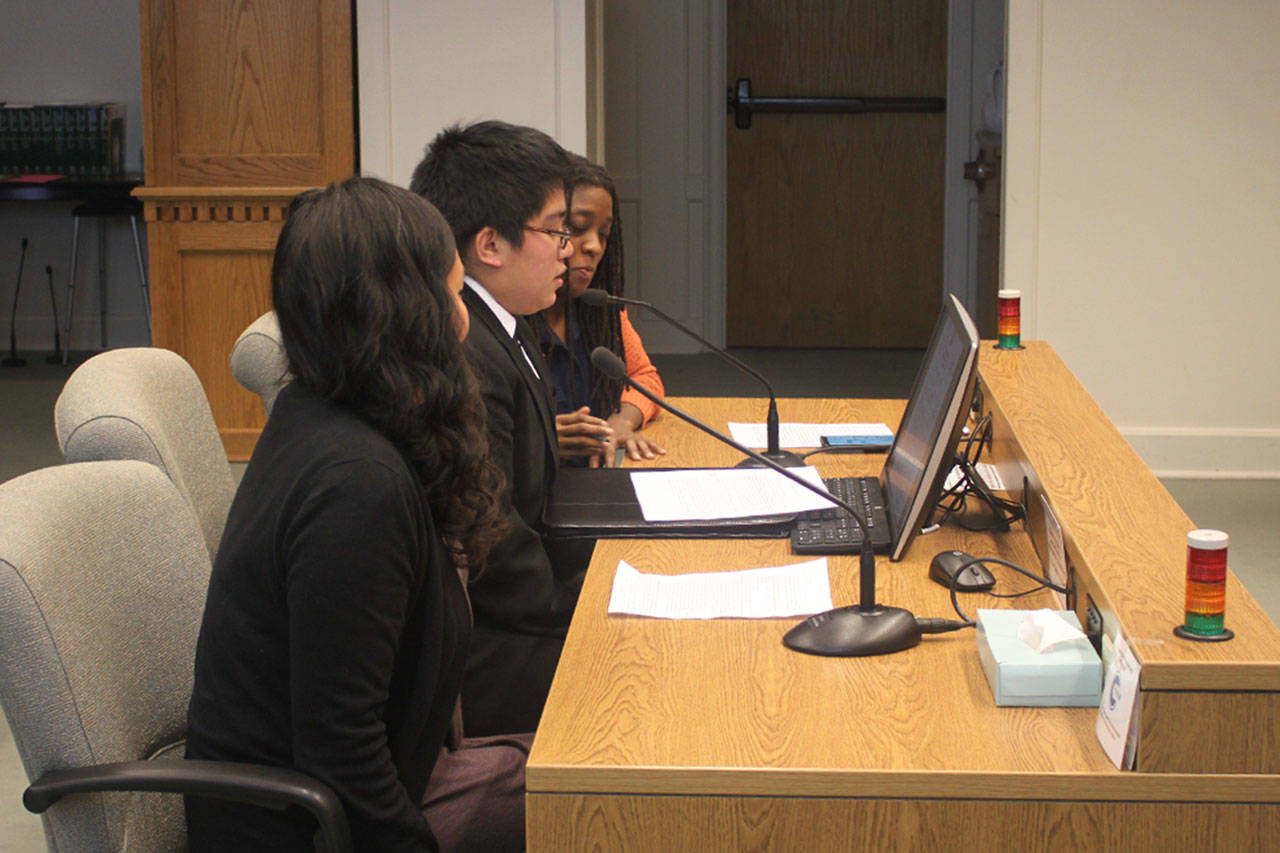 Orion Olsen, middle, testifies in favor of Senate Bill 5324 on behalf of the Mockingbird Society. In his testimony, Olsen spoke of the importance of public school faculty being educated on the resources available to homeless youth. Samie Iverson, left, and Katara Jordan also testified in favor of the bill, one that would widen accessibility of grants for homeless children in Washington state. (Emma Scher/WNPA Olympia News Bureau)