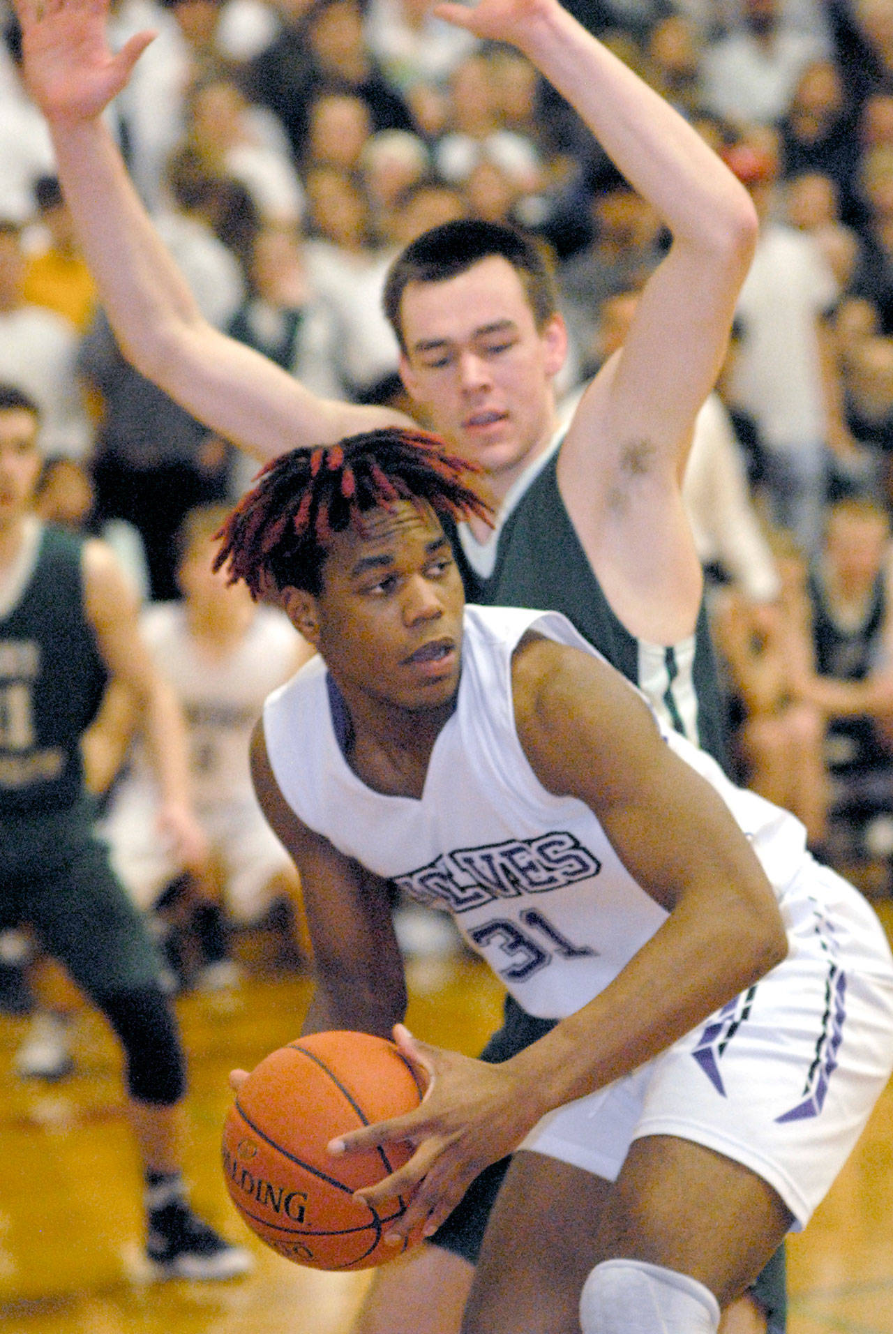 Keith Thorpe/Peninsula Daily News Sequim’s Keeshawn Whitney looks to pass as Port Angeles’ Liam Clark defends the basket on Friday night at Sequim High School.