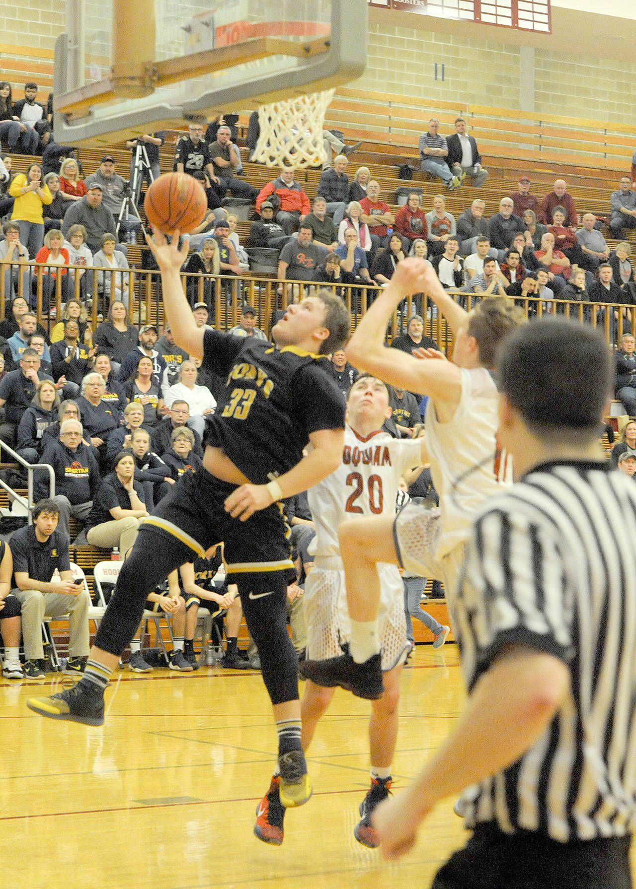 Lonnie Archibald/for Peninsula Daily News Forks’ Cort Prose drives and scores against Hoquiam’s Dane McMillian, 20, and Cameron Branstead. The Spartans won the Evergreen League championship with the road victory.
