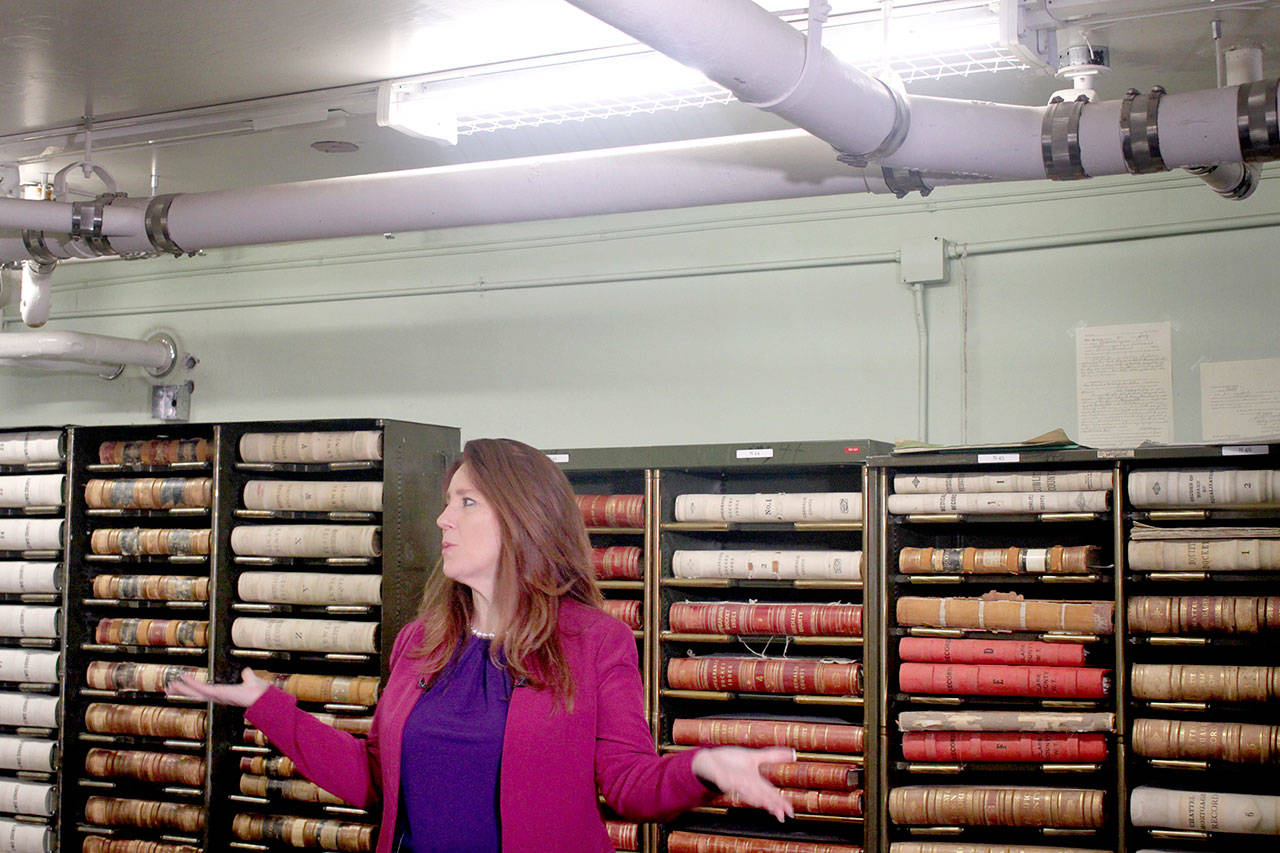 State Secretary of State Kim Wyman shows off the 1962 State Archive building. The pipe above her head has leaked water in the past. (Emma Scher/WNPA Olympia News Bureau)