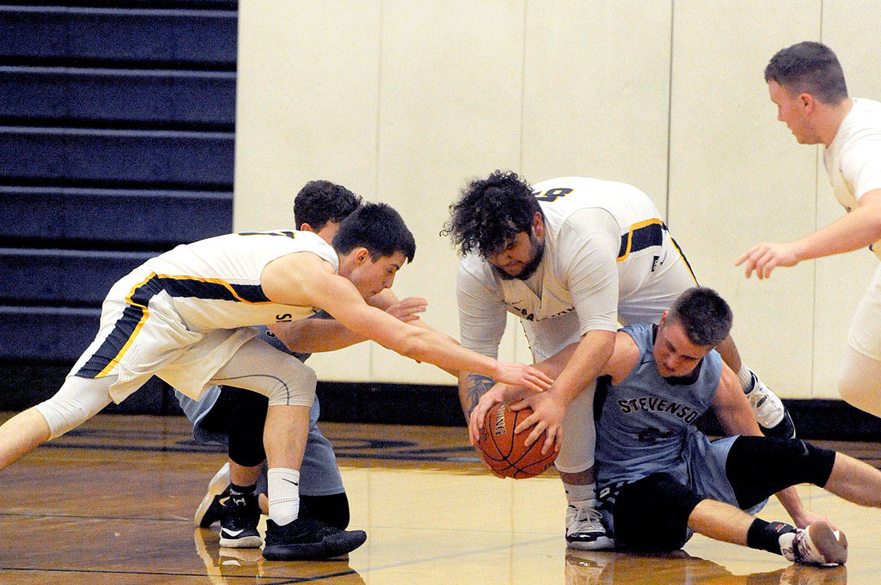 Lonnie Archibald/for Peninsula Daily News From left, Brandon Baar, Iziah Morton, and Cort Prose of Forks get the steal from Stevenson. The Spartans won their Class 1A Southwest District IV opener 77-67 over the Bulldogs.