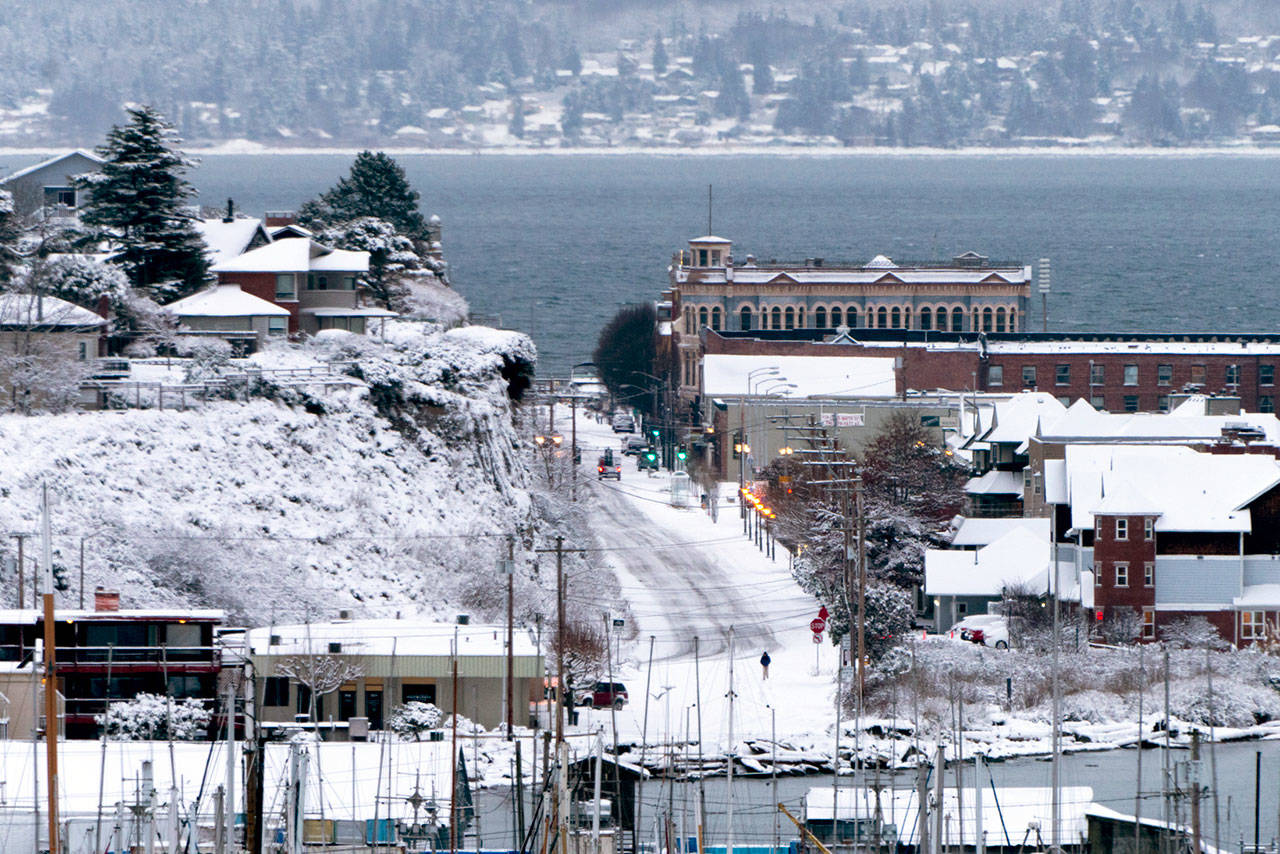 Water Street in downtown Port Townsend is devoid of activity except for two motor vehicles and a lone pedestrian on Saturday morning. (Steve Mullensky/for Peninsula Daily News)