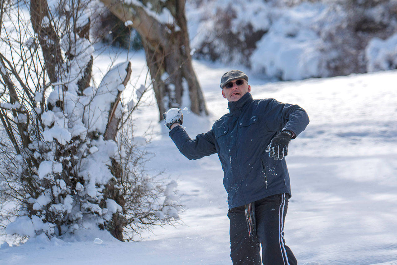 Steve Veltkamp takes aim during a community snowball fight in Port Angeles on Sunday. (Jesse Major/Peninsula Daily News)