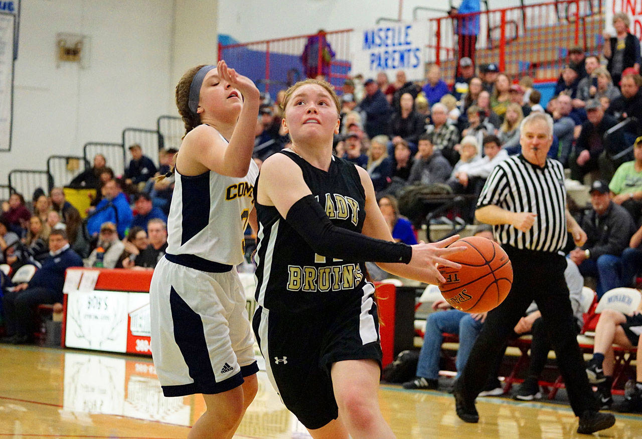 Clallam Bay’s Hannah Olson, right, drives past Naselle point guard Bella Colombo during a Class 1B State Regional round contest Friday at Mark Morris High School in Longview. Rob Hilson
