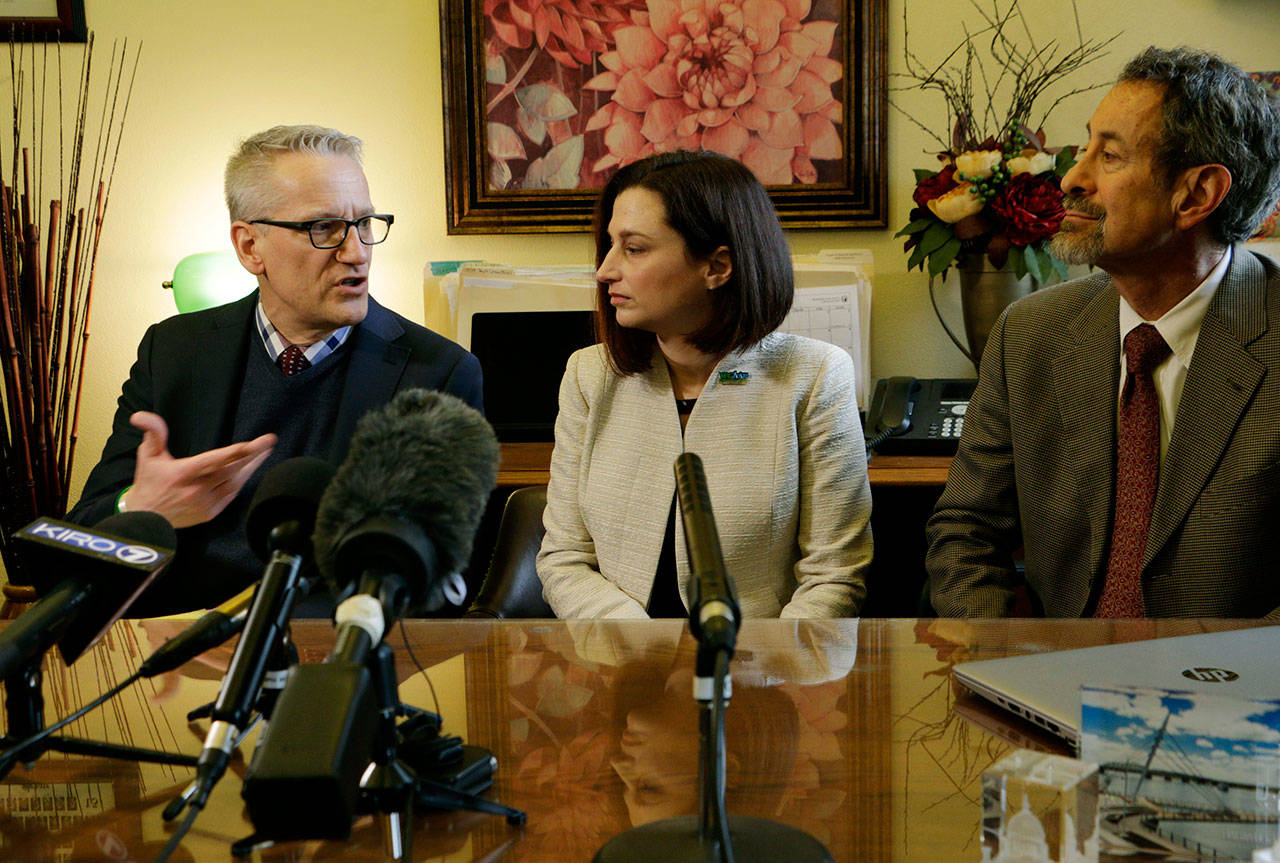 Department of Health Secretary John Wiesman, left, talks to the media about the recent measles outbreak as Dr. Robyn Rogers, center, and Dr. Gary Goldbaum of the Washington State Medical Association look on, Wednesday in Olympia. (Rachel La Corte/The Associated Press)