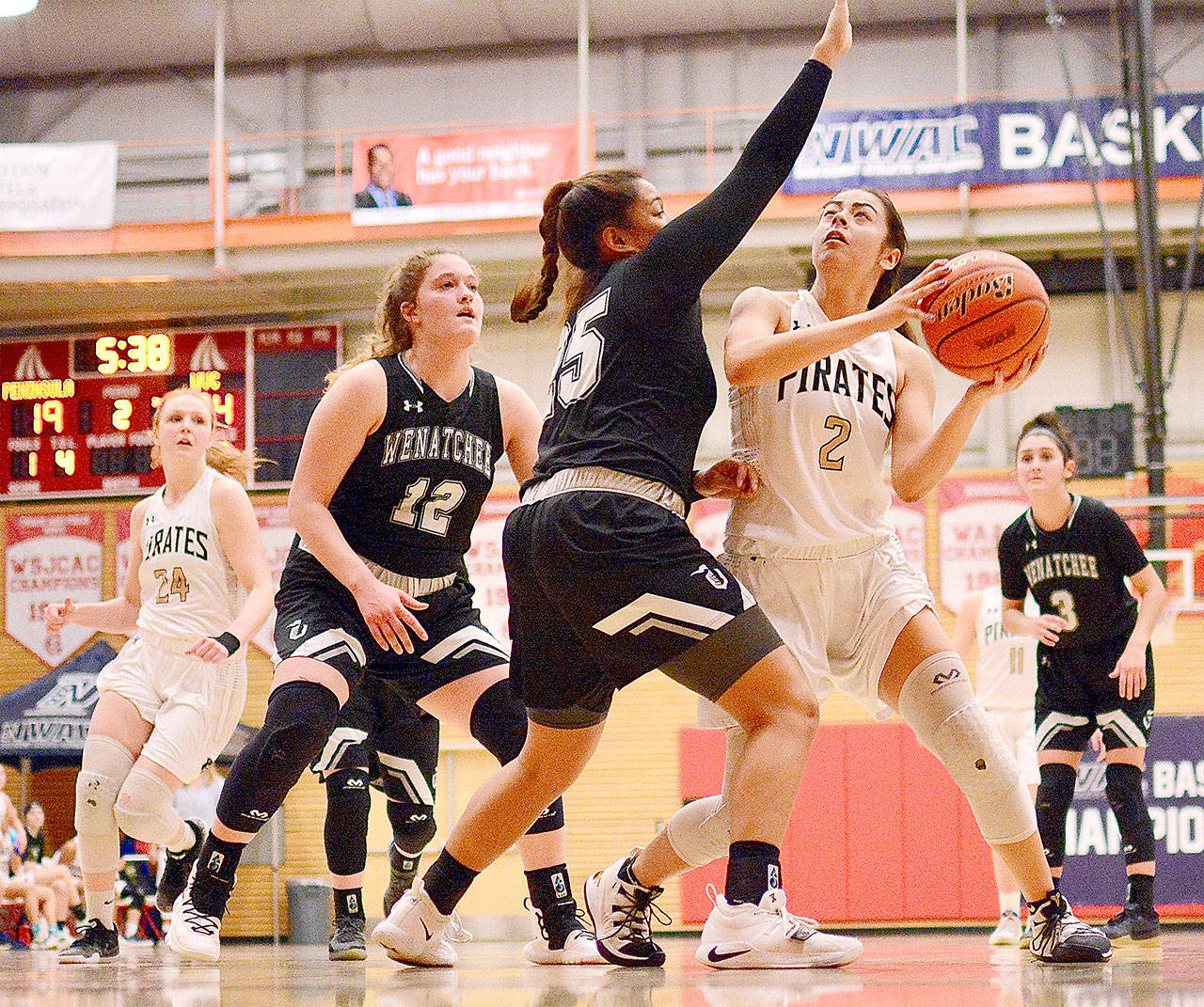 Jay Cline Peninsula’s Leilani Padilla looks to shoot against Wenatchee Valley’s Cariann Kunkel (12) and Ashley Peralta (25). At left is Peninsula’s Kameron Bowen.