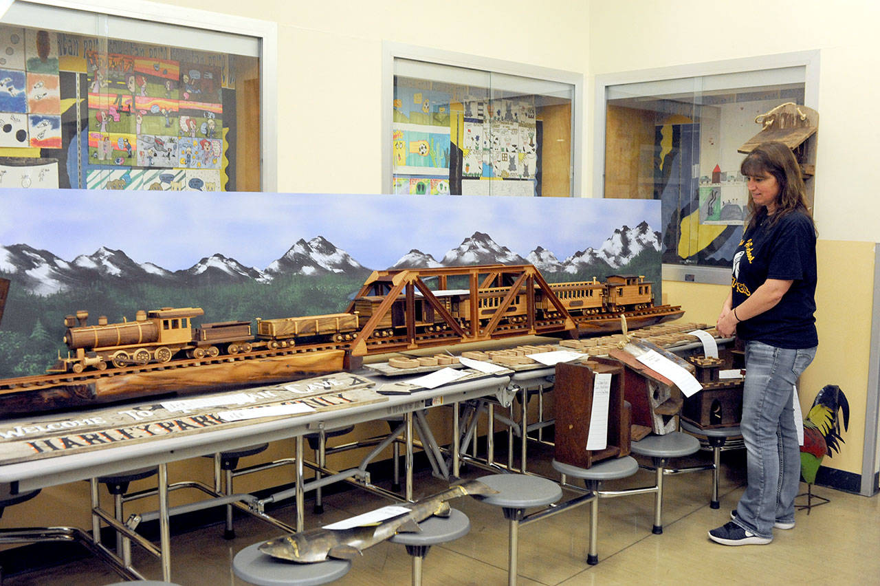 Sabrina Bees of Forks checks out a wooden train and trestle donated by the Olympic Corrections Center. The center again was a large contributor to the fundraising auction, as it has been in the past. (Lonnie Archibald/for Peninsula Daily News)