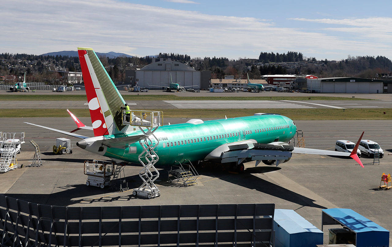 A worker on a lift works Friday on a Boeing 737 Max 8 being built for SpiceJet at Renton Municipal Airport in Renton. (Ted S. Warren/The Associated Press)