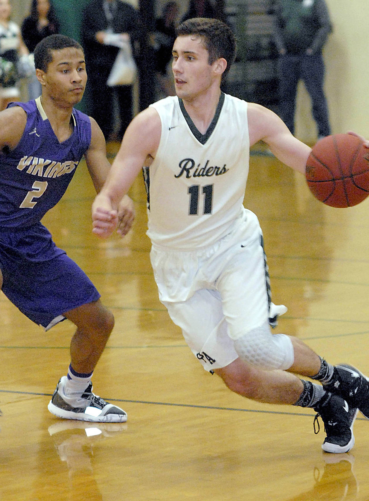 <strong>Keith Thorpe</strong>/Peninsula Daily News Port Angeles’ Kyle Benedict, right, sweeps past North Kitsap’s Kobe McMillian during a game in January in Port Angeles.