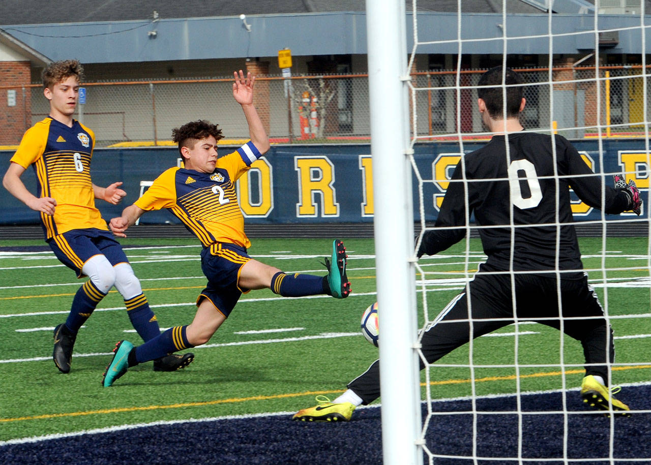 Lonnie Archibald/for Peninsula Daily News Forks’ Juan Flores Contreras, center, scores his second goal during a nonleague game against Coupeville on Monday at Spartans Stadium. Looking on for Forks is Tony Muro, left.