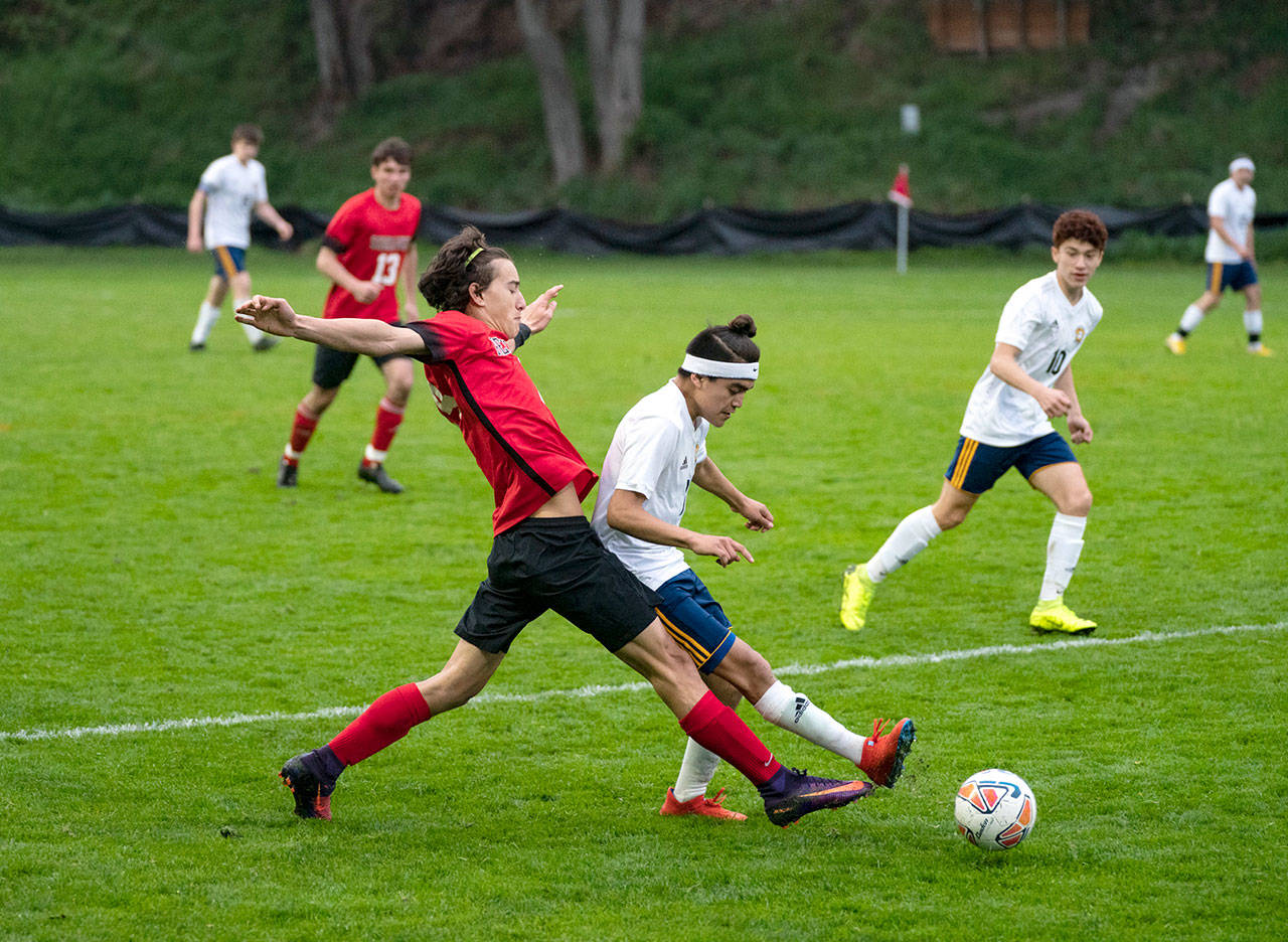 Port Townsend’s Silas DeWyse’ pokes the ball away from Forks’ Hugo Sandoval during a boys soccer match Tuesday at Memorial Field in Port Townsend.                                Steve Mullensky/for Peninsula Daily News