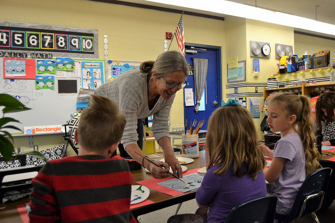 Helen Haller Elementary kindergartners in Stephanie Grotzke-Nash’s class listen in for advice from Carrie Rodlend about how best to paint a sheep. When she’s not teaching art in classrooms, Rodlend works with children and adults in Dungeness making art. Her latest show on Saturday at 562 Holgerson Road will focuse on land- and seascapes. Matthew Nash/Olympic Peninsula News Group