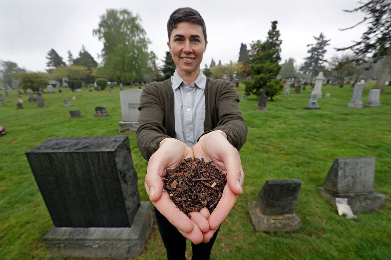Katrina Spade, the founder and CEO of Recompose, displays a sample of the compost material left from the decomposition of a cow, using a combination of wood chips, alfalfa and straw, as she poses last Friday in a cemetery in Seattle. (Elaine Thompson/The Associated Press)