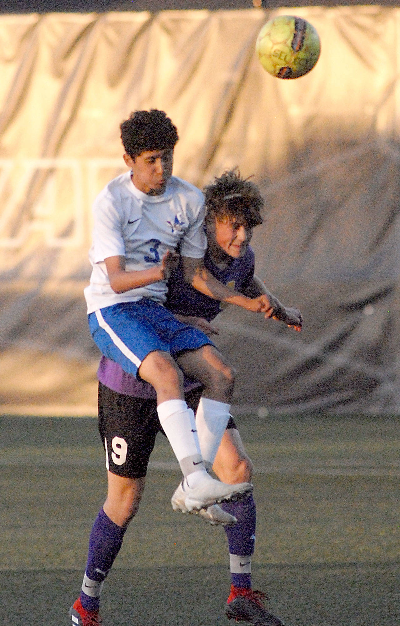 Keith Thorpe/Peninsula Daily News Sequim’s Adrian Funston, right, bulls his way past Washington’s David Baltazar for a header in the first half during Tuesday’s playoff match at Peninsula College in Port Angeles.