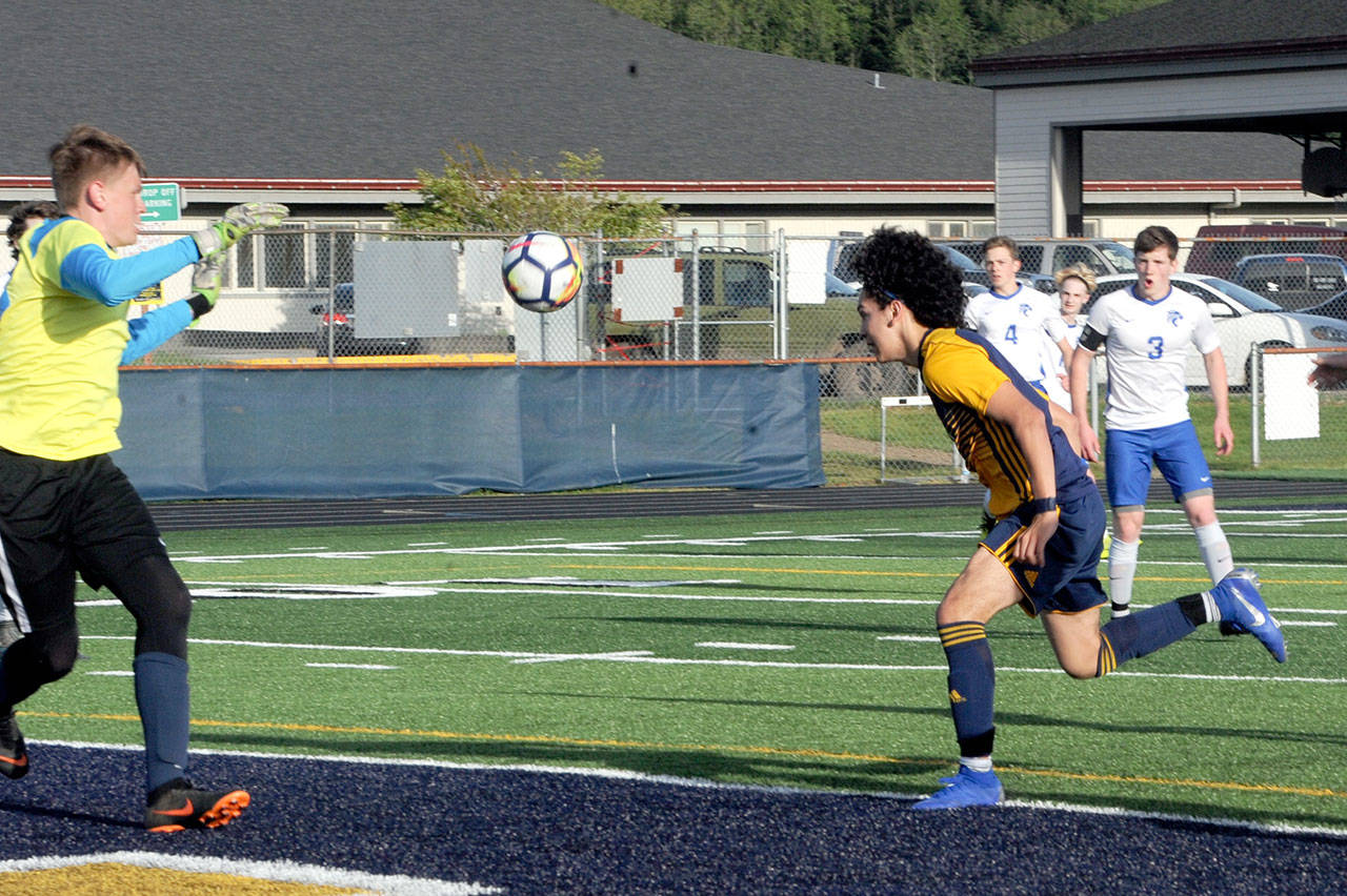 Lonnie Archibald/for Peninsula Daily News Forks’ Tony Hernandez-Flores heads the ball past La Center goalkeeper Shawn Child for a goal in the Spartans’ 3-2 Southwest District 4 playoff win over the Wildcats.