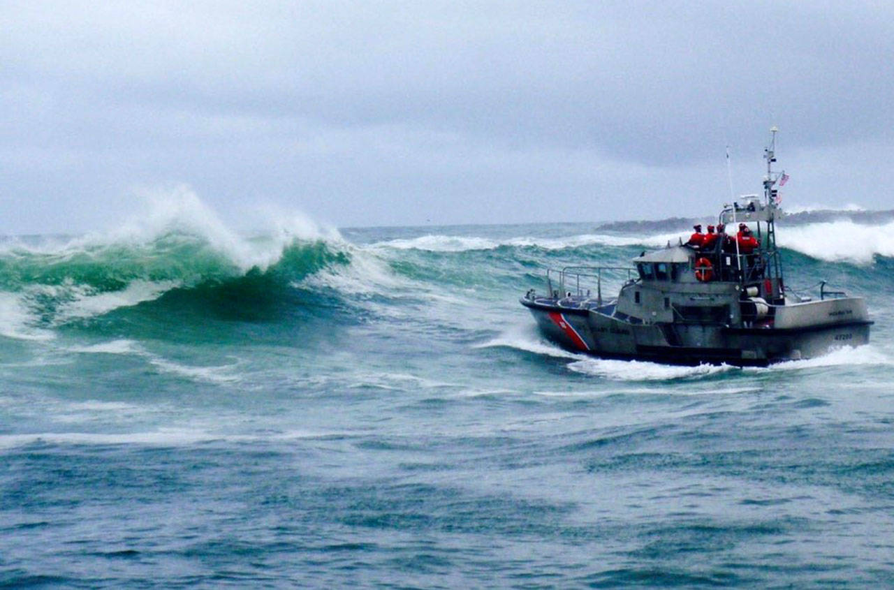A U.S. Coast Guard boat crew responds on Jan. 8 to three fishermen in the water after the commercial fishing vessel Mary B II capsized while crossing the Yaquina Bar off the coast of Newport, Ore. (U.S. Coast Guard via AP)