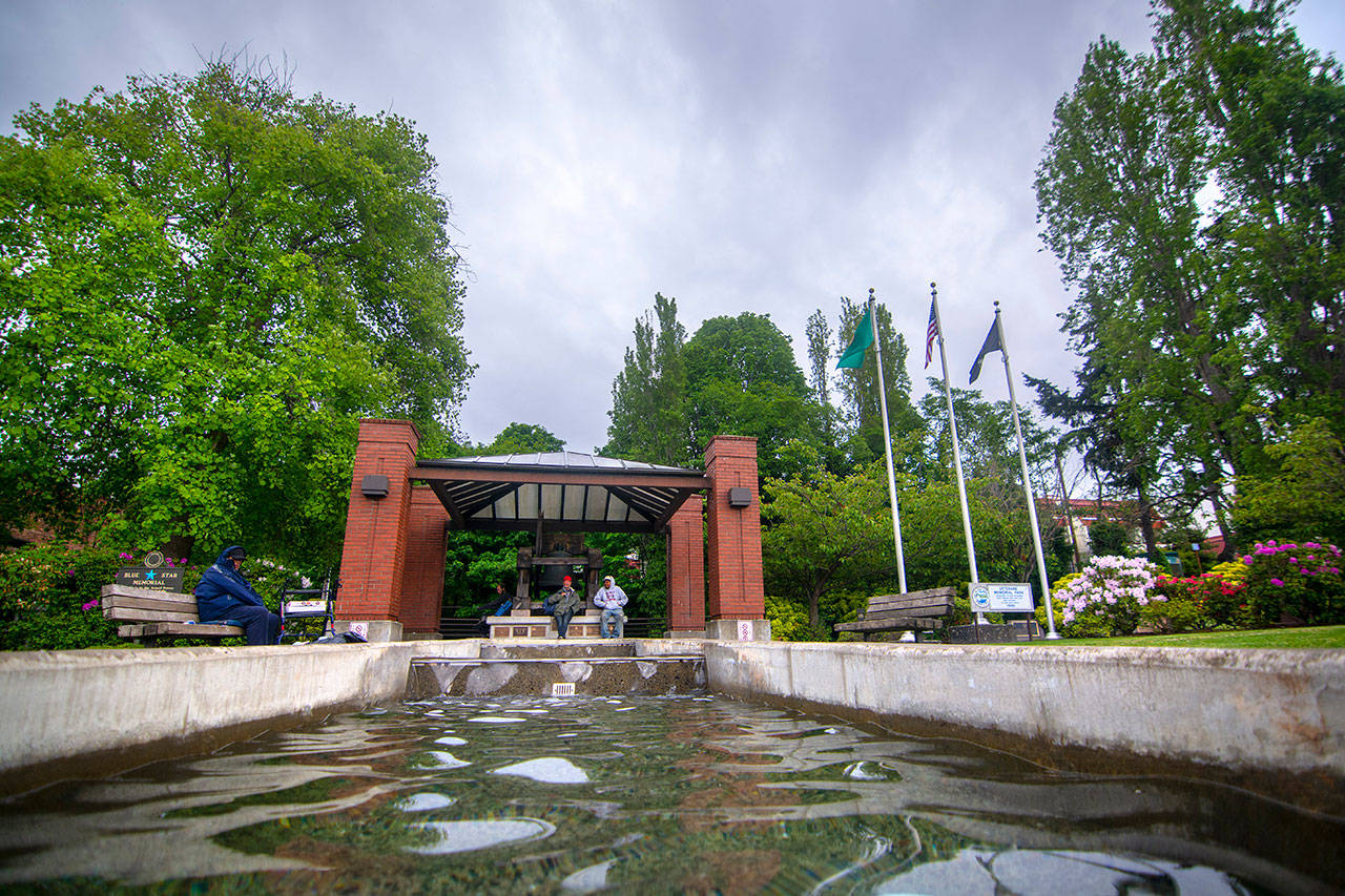 People sit under cover at Veterans Memorial Park in Port Angeles during a light rain. (Jesse Major/Peninsula Daily News)