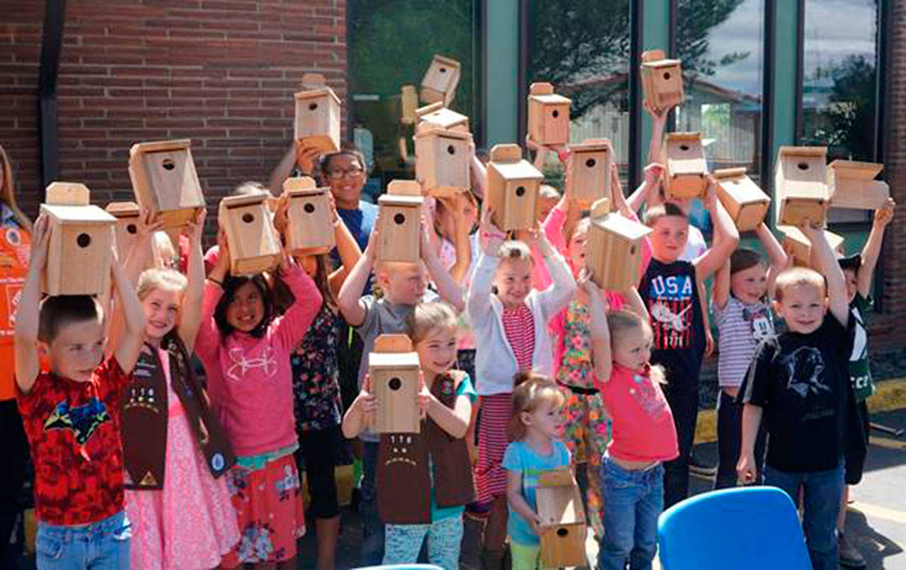 Participants hold up their birdhouses at the 2017 build a birdhouse workshop.