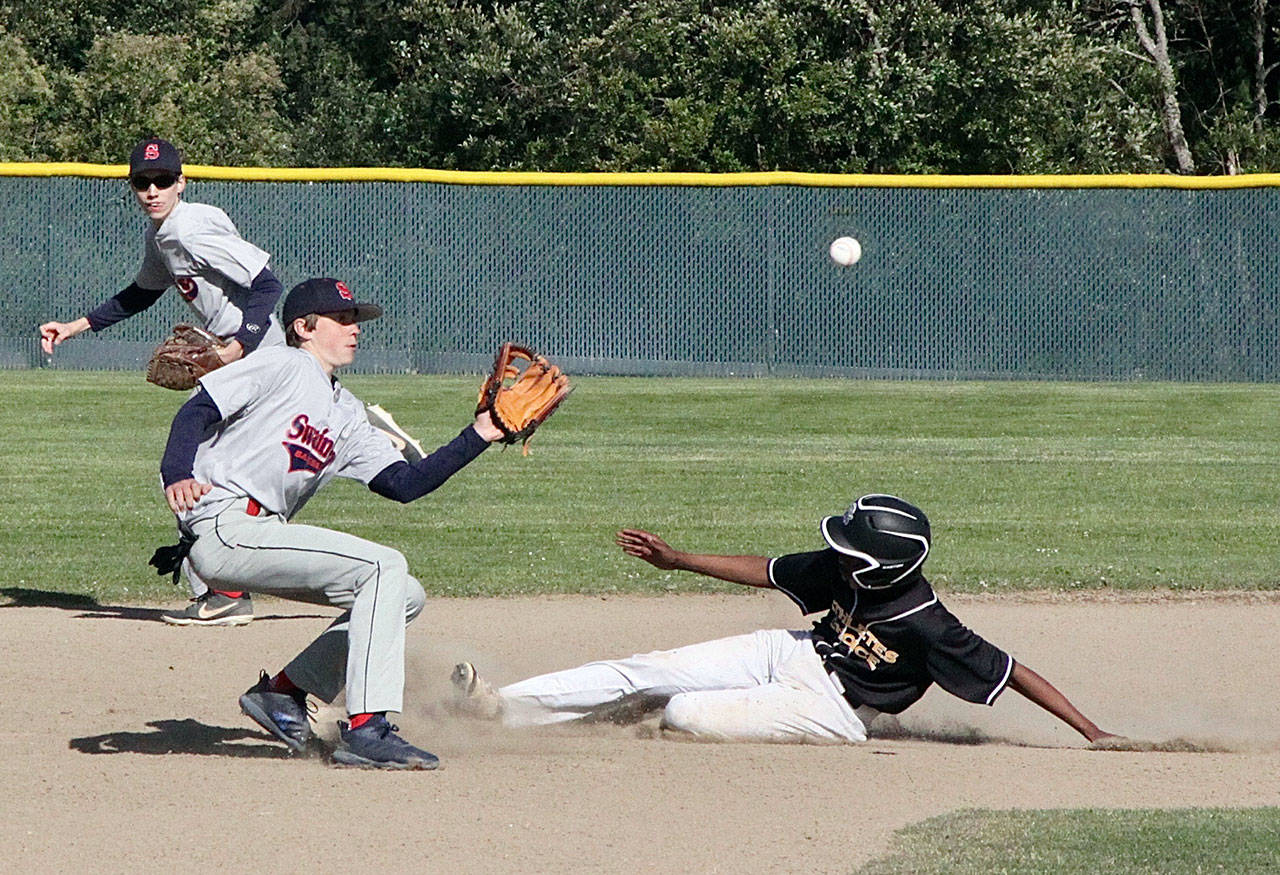 Dave Logan/for Peninsula Daily News Swain’s Parker Nickerson, left, eyes the throw to second as Athletes’ Choice baserunner Elisha Dujue slides safely into second base during the Olympic Junior Babe Ruth Championship Thursday at Volunteer Field.