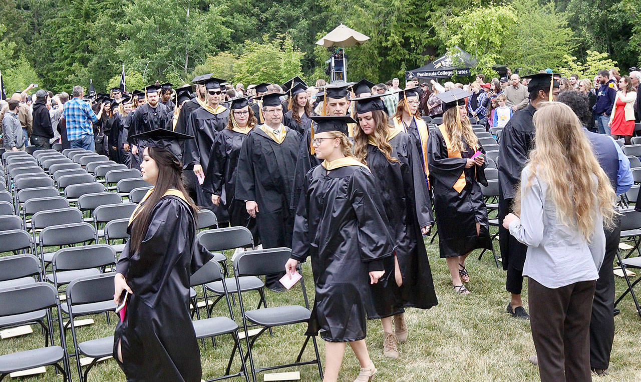 Peninsula College graduates file into the outdoor ceremony site on Saturday afternoon in front of a standing-room-only crowd of family and friends on the Port Angeles campus at 1502 E. Lauridsen Blvd. The 57th commencement ceremony awarded degrees and certificates to 574 students. Speakers include Dwayne Johnson, board of trustees chairman, and David Harvey, student body vice president. (David Logan/for Peninsula Daily News )