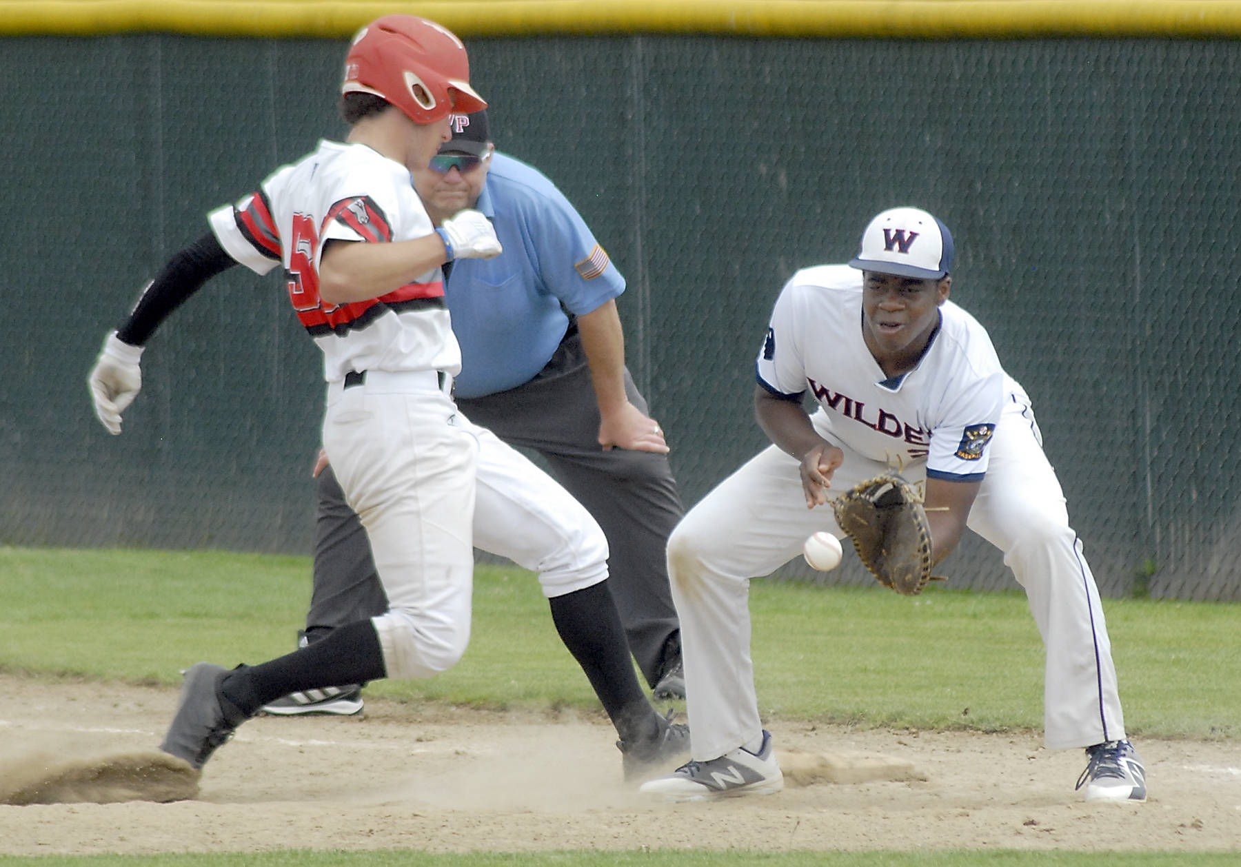<strong>Keith Thorpe</strong>/Peninsula Daily News Wilder Junior first baseman Trey Baysinger, right, tries to catch Australia White’s Charlie Cullins off the bag in the fourth inning on Wednesday at Volunteer Field in Port Angeles.