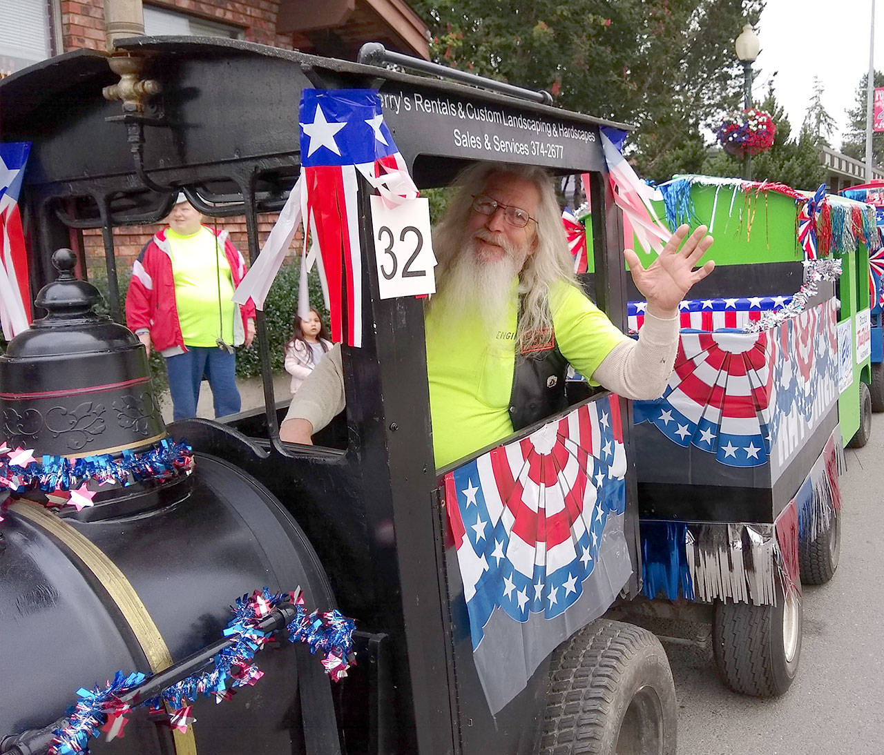 Rick Seguin drives the WEBPA kiddie train around the crowded street during Forks Midnight Madness. (Zorina Barker/for Peninsula Daily News)