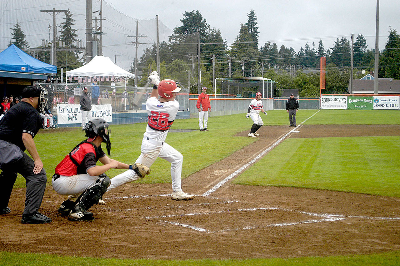 Pierre LaBossiere/Peninsula Daily News Australia Blacks Liam MacDonald (26) takes a cut with teammate Blake Cavill on third base in the championship game of the Firecracker Tournament. Australia Black won 11-1 to take the title.