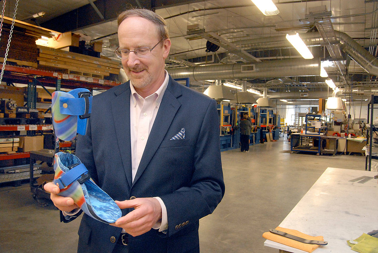 Dave Walter, CEO of the Composite Recycling Technology Center, holds an orthotic limb that utilizes a carbon composite spring manufactured at the Port Angeles facility. (Keith Thorpe/Peninsula Daily News)