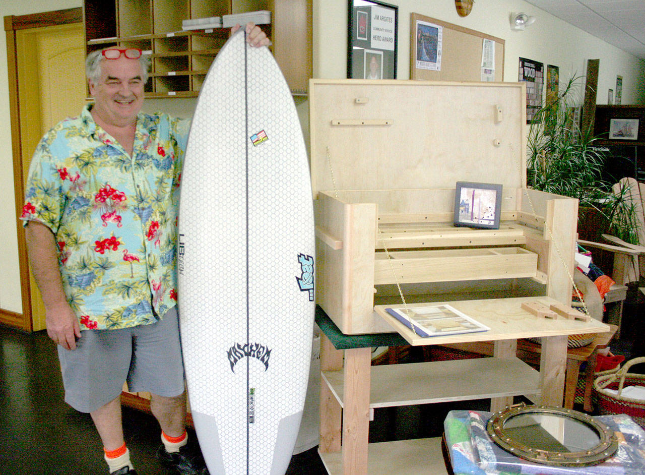 Jim “Kiwi” Ferris, owner of Edensaw Woods in Port Townsend and founder of the Edensaw Community Cancer Foundation, displays some of the items that will be available in live and silent auctions Saturday during the 11th annual Brewfest at Port Townsend Brewing Co. (Brian McLean/Peninsula Daily News)