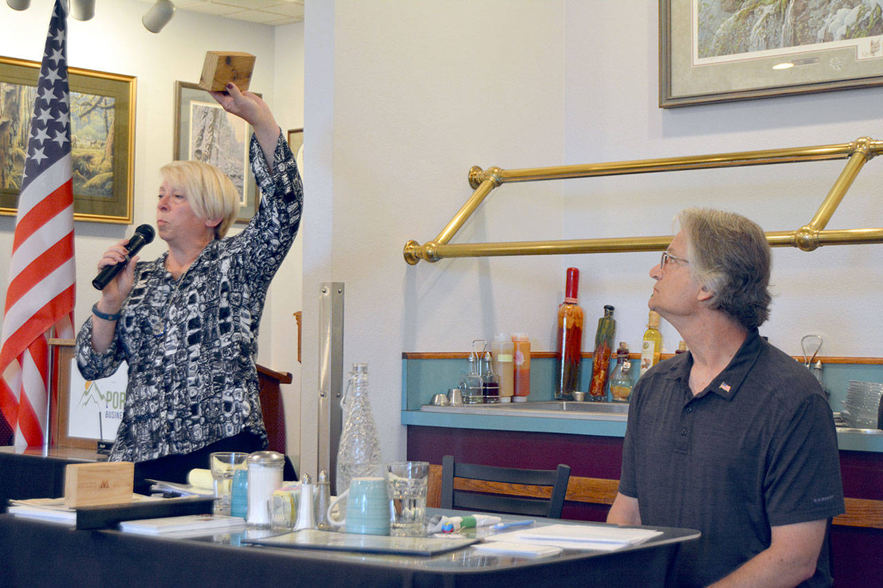 Port of Port Angeles Commissioner Connie Beauvais displays a block of thermally modified hemlock that the port is participating in developing during a general election forum Tuesday that included her challenger, Maury Modine. (Paul Gottlieb/Peninsula Daily News)