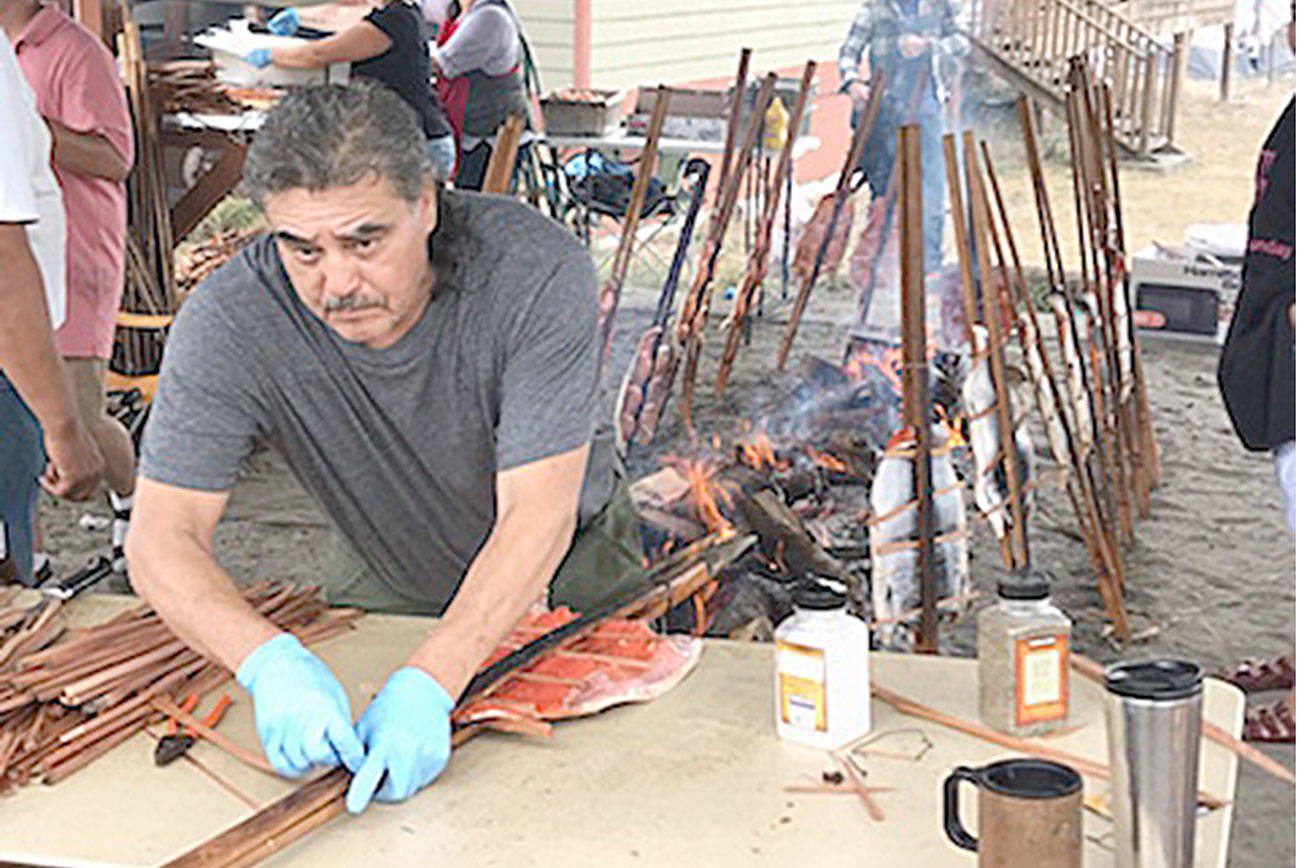 Monty McAlpin prepares Sokeye salmon fish filets from among 400 fish that were caught for the Makah Days salmon bake Saturday. (Paul Gottlieb/Peninsula Daily News)