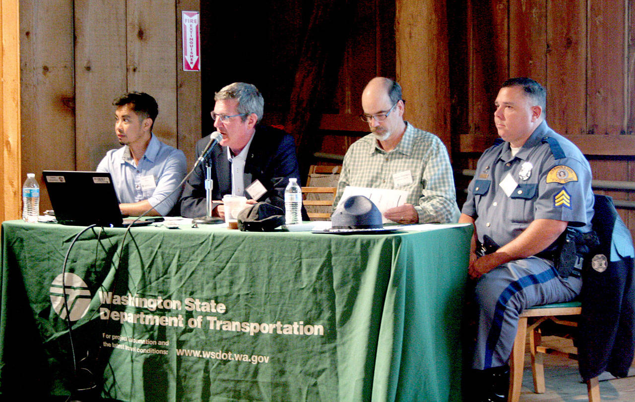 John Wynands, second from left, the Olympic Region administrator for the state Department of Transportation, presents the agency’s plans Thursday night in Quilcene for a roundabout at state Highway 104 and Paradise Bay and Shine roads. He is flanked by Joseph Perez, WSDOT’s planning and project manager, left, and Monte Reinders, Jefferson County’s public works director. State Patrol Sgt. Brian George is on the far right. (Brian McLean/Peninsula Daily News)