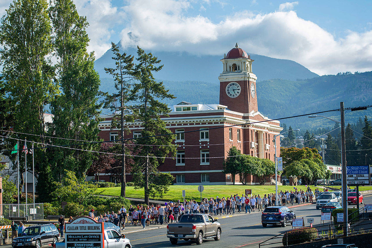 About 150 people walk north on Lincoln Street during the fifth annual Overdose Awareness Day walk in Port Angeles on Saturday. (Jesse Major/Peninsula Daily News)