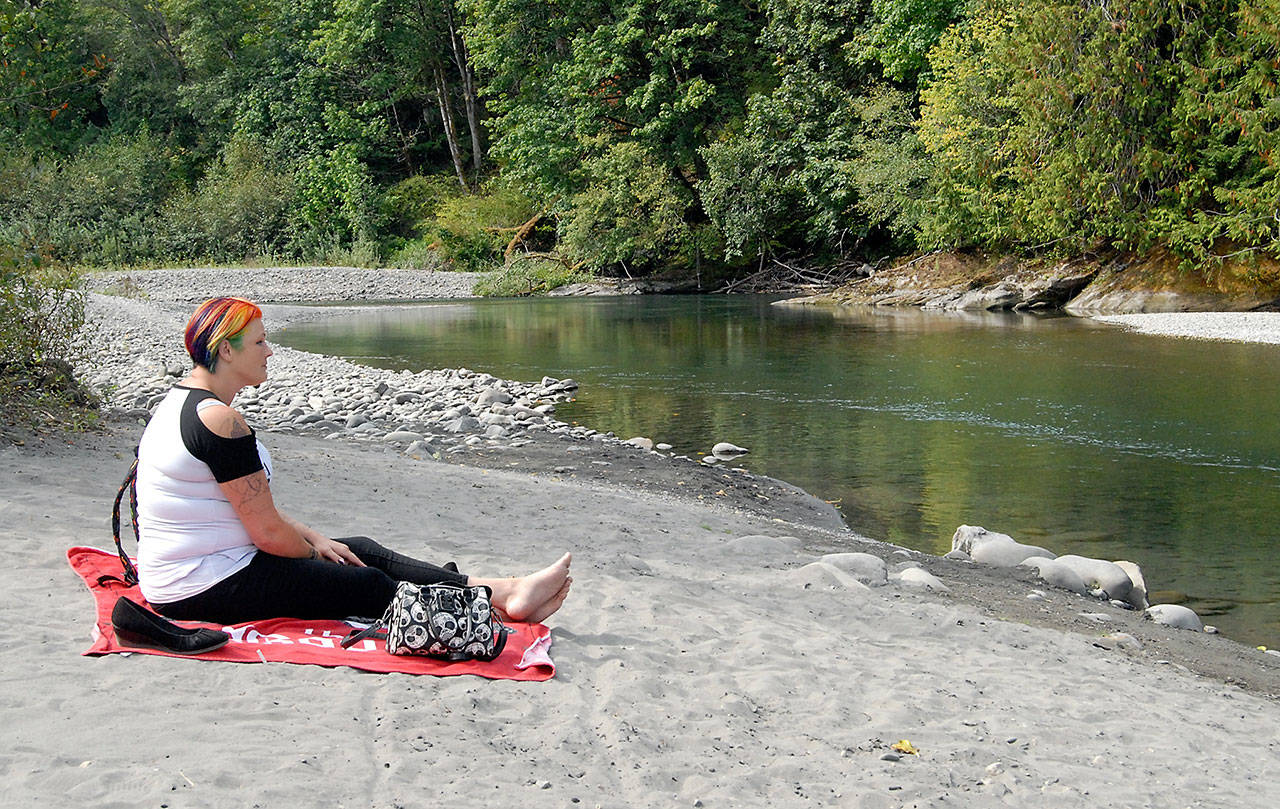 Shawna Nicholls of Port Angeles watches the Elwha River beneath the Elwha River Bridge west of Port Angeles on Thursday. Low flow rates on the river have prompted the city of Port Angeles to consider Stage 3 water restrictions. (Keith Thorpe/Peninsula Daily News)