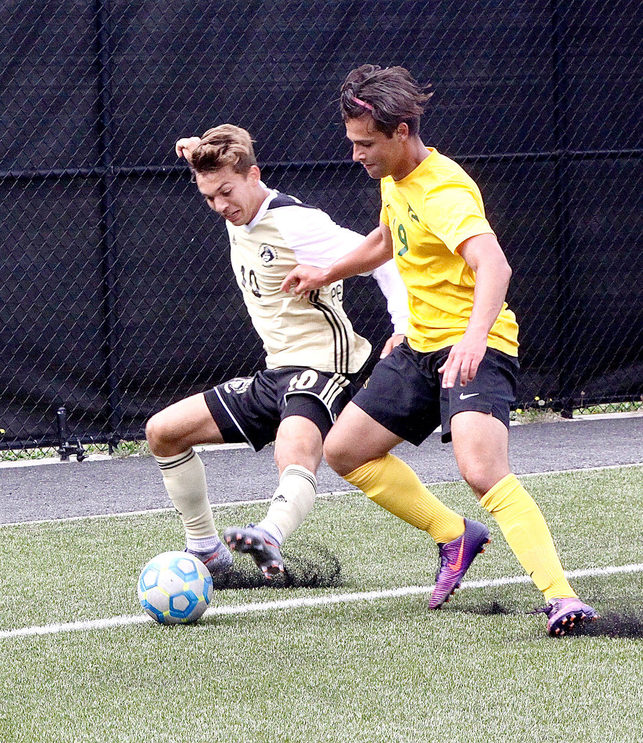 Peninsula College’s Mason Haubrich, left, battles with Shoreline’s Brandon Stapleton during Peninsula’s 9-0 win over the Dolphins on Saturday. Haubrich had a goal and an assist. (Dave Logan/for Peninsula Daily News)