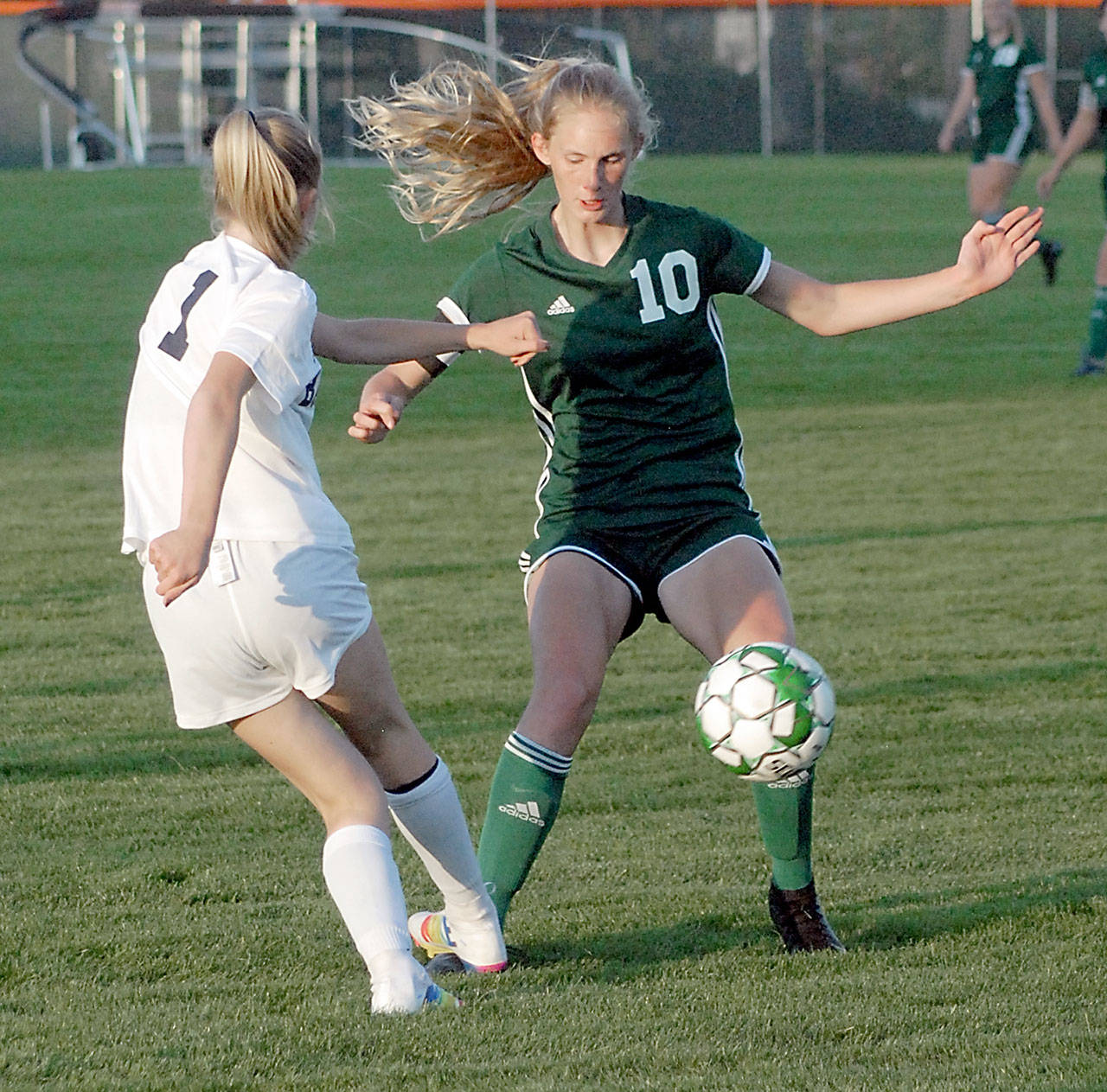 Keith Thorpe/Peninsula Daily News Port Angeles’ Millie Long, right, fends of the defense of Bainbridge’s Leah Brase on Tuesday at Port Angeles Civic Field.