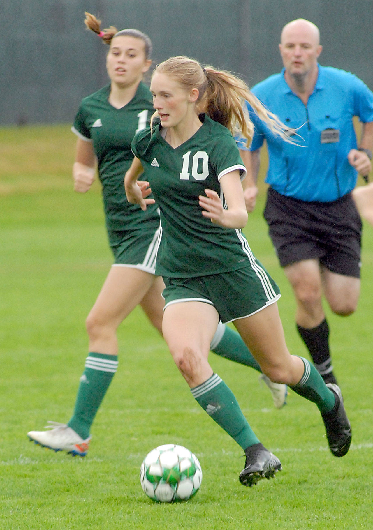 Keith Thorpe/Peninsula Daily News Port Angeles’ Millie Long, front, is followed by teammate Bailee Larson as she drives toward the Sequim goal on Thursday night in Port Angeles.