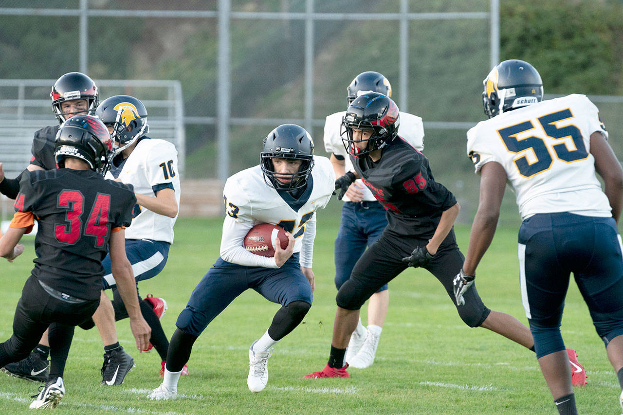 Spartan Jake Weakley runs through a hole set up by his defense during a game against the Port Townsend Redhawks played in memorial Field on Friday. (Steve Mullensky/for Peninsula Daily News)