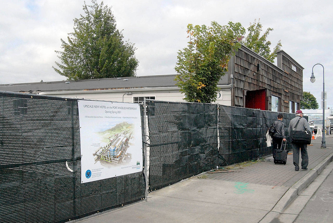 Construction fencing surrounds the building that once housed Necessities & Temptations on Friday as demolition crews prepare the site to remove buildings to make way for a luxury hotel being built by the Lower Elwha Klallam Tribe in downtown Port Angeles. (Keith Thorpe/Peninsula Daily News)